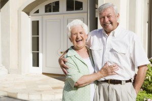 Senior couple standing outside house